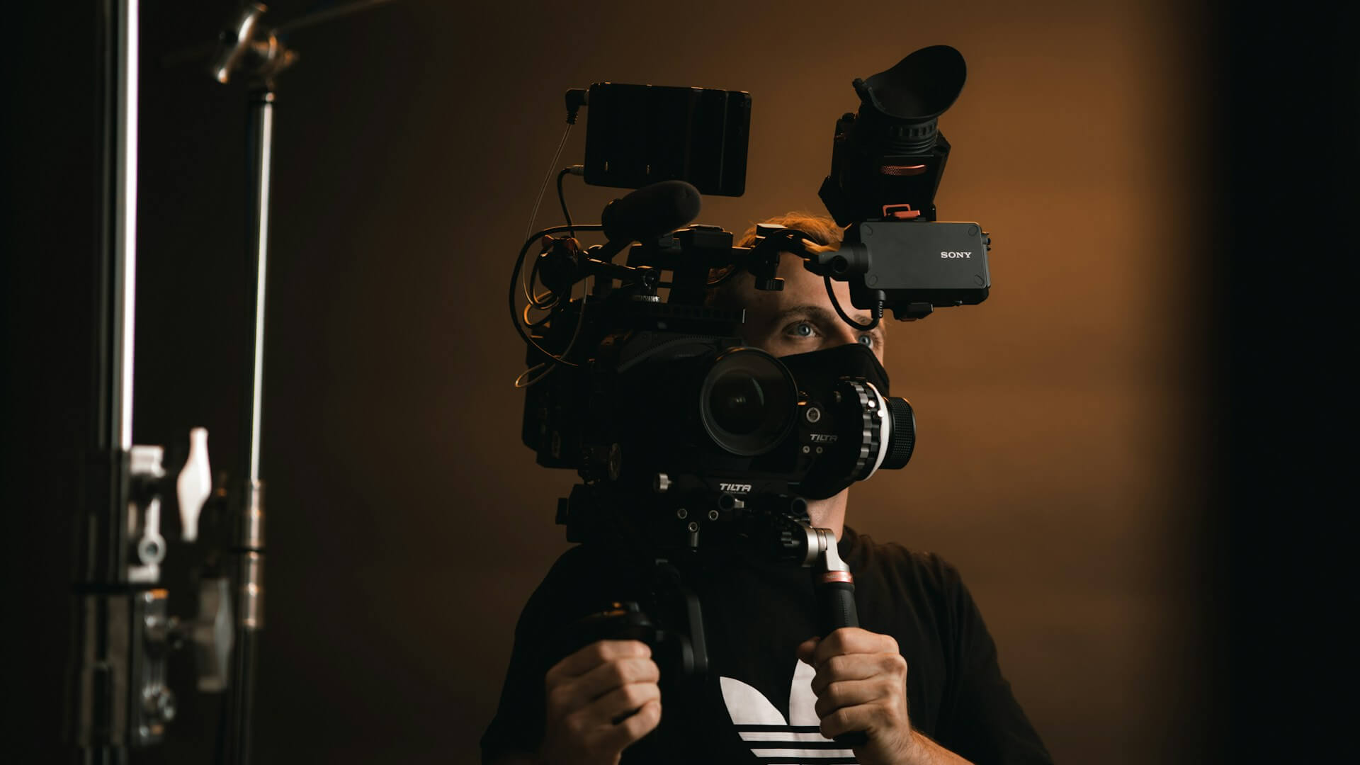 Man holding a big camera to produce a video